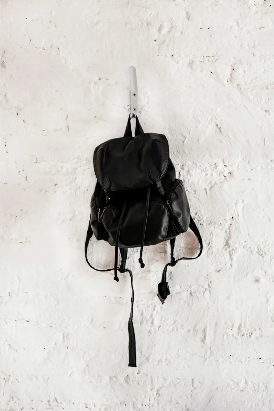 Black leather backpack on wall