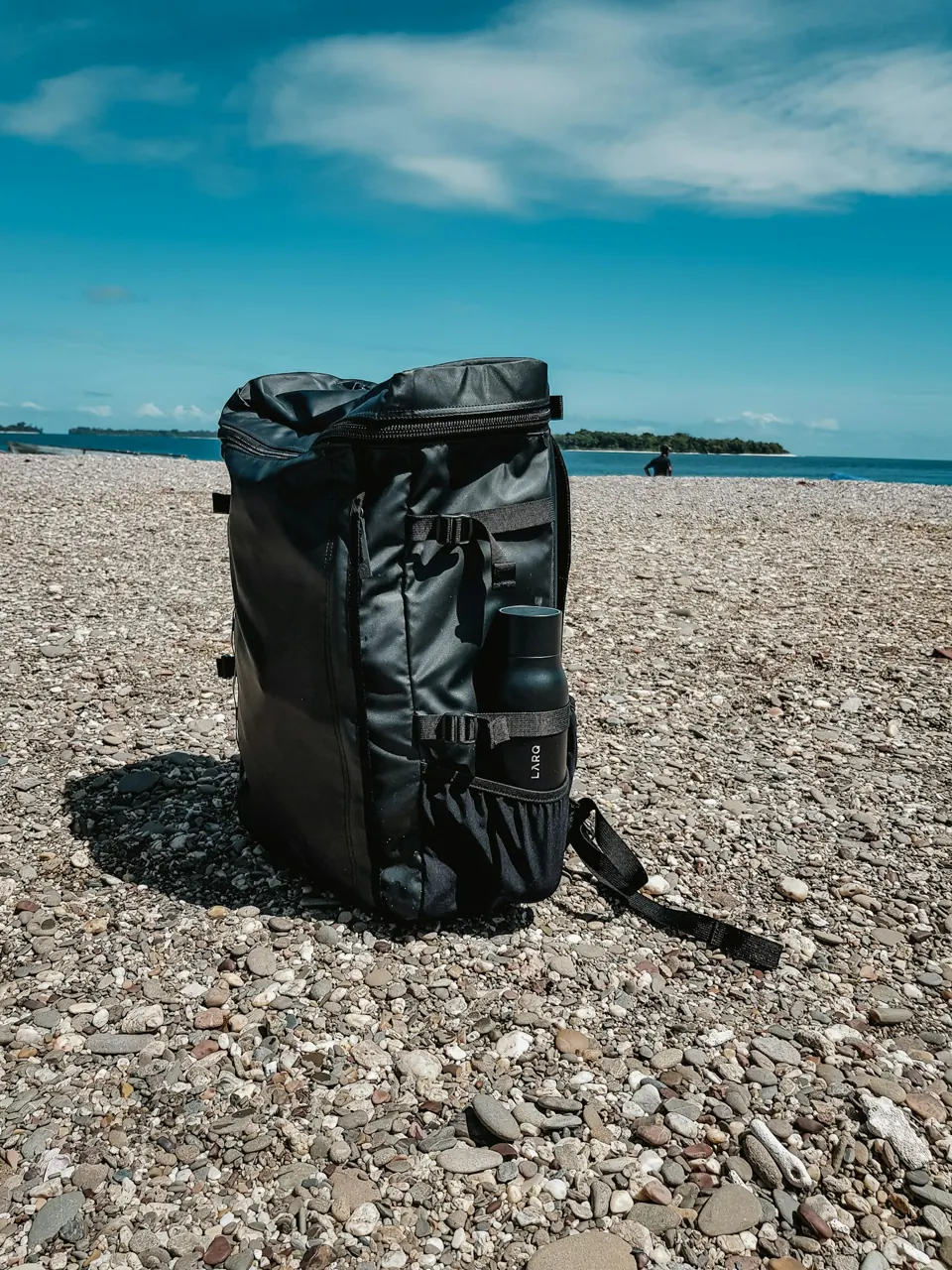 Black leather bag on a rocky beach