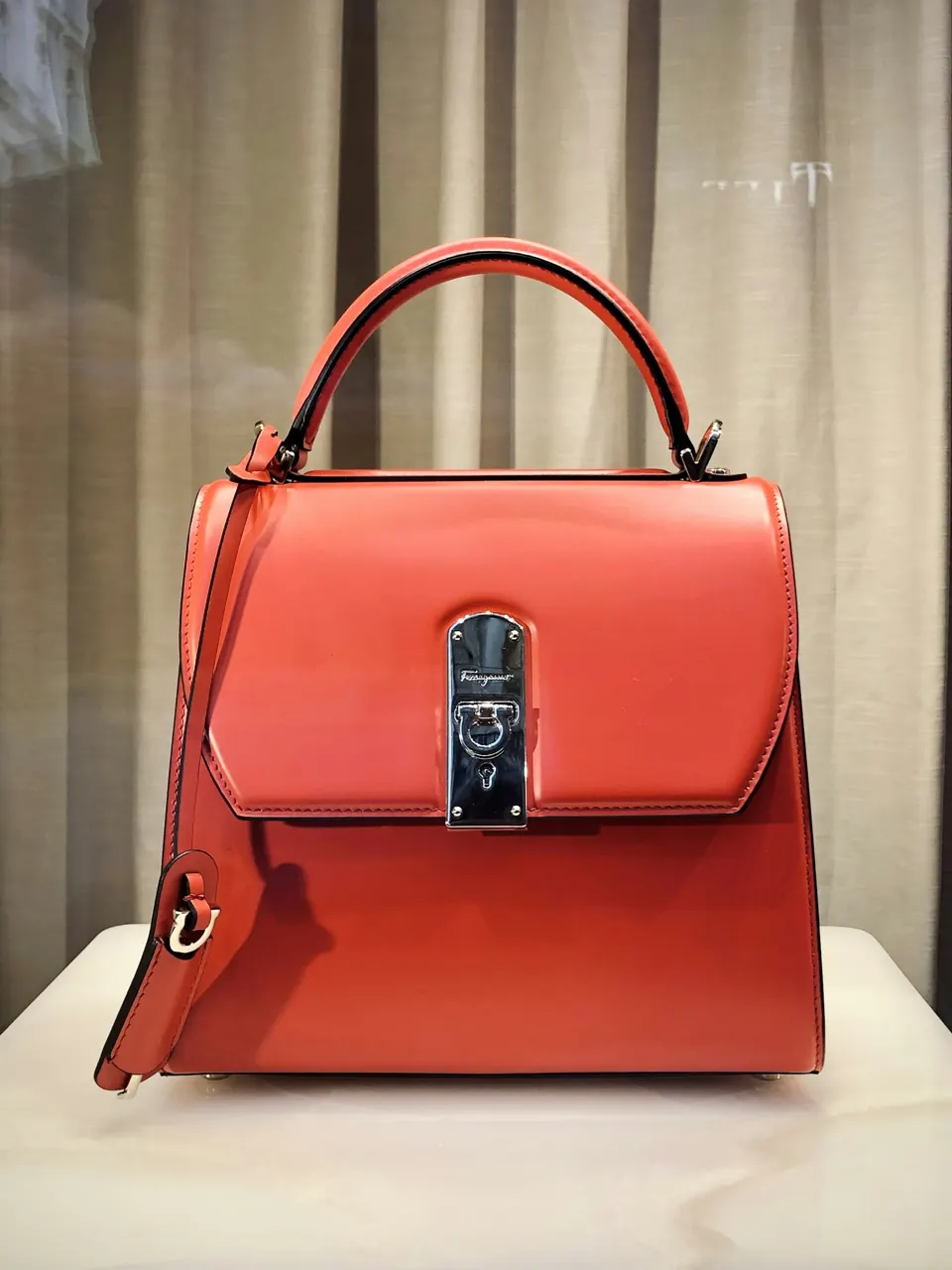 Red leather handbag on white table