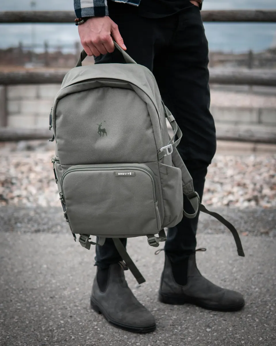Person in black jacket carrying gray backpack