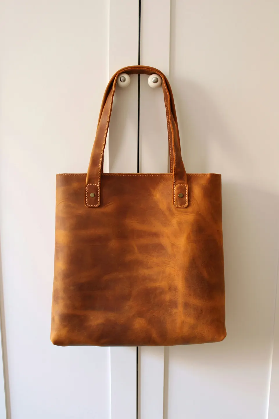 Brown leather handbag on white table
