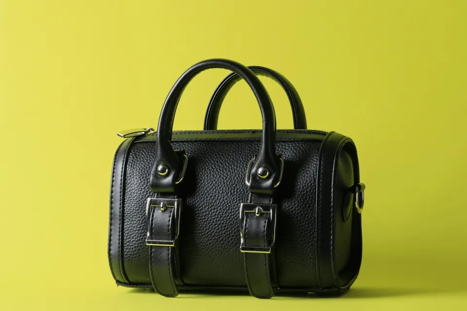 A black leather bag on a yellow background