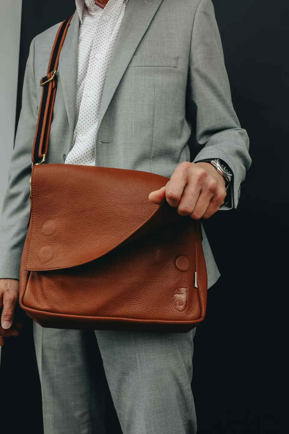 A man in a suit holding a brown bag