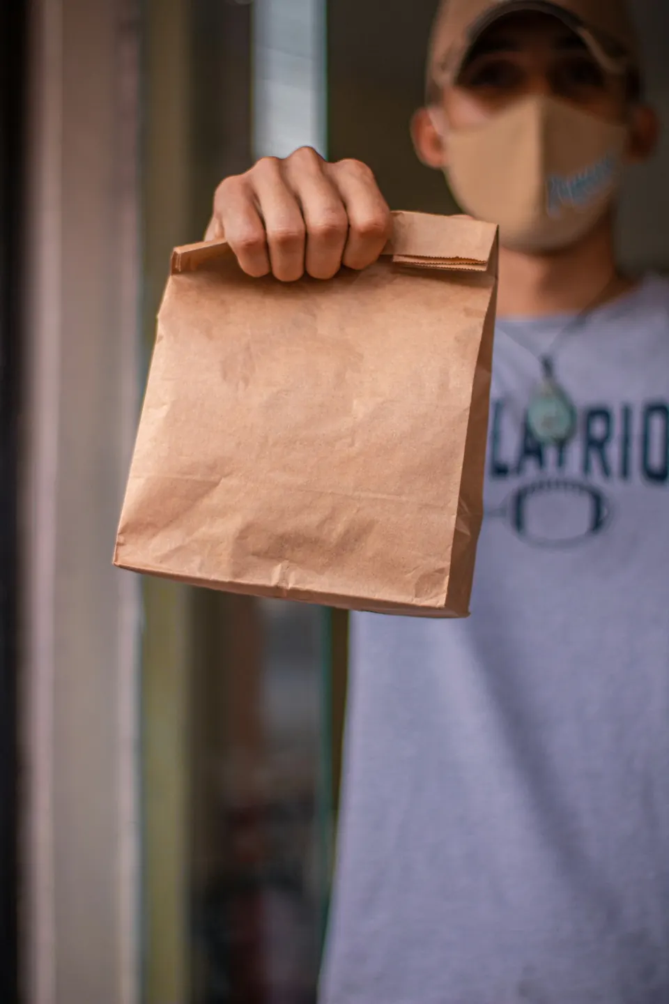 A man holding a brown delivery bag