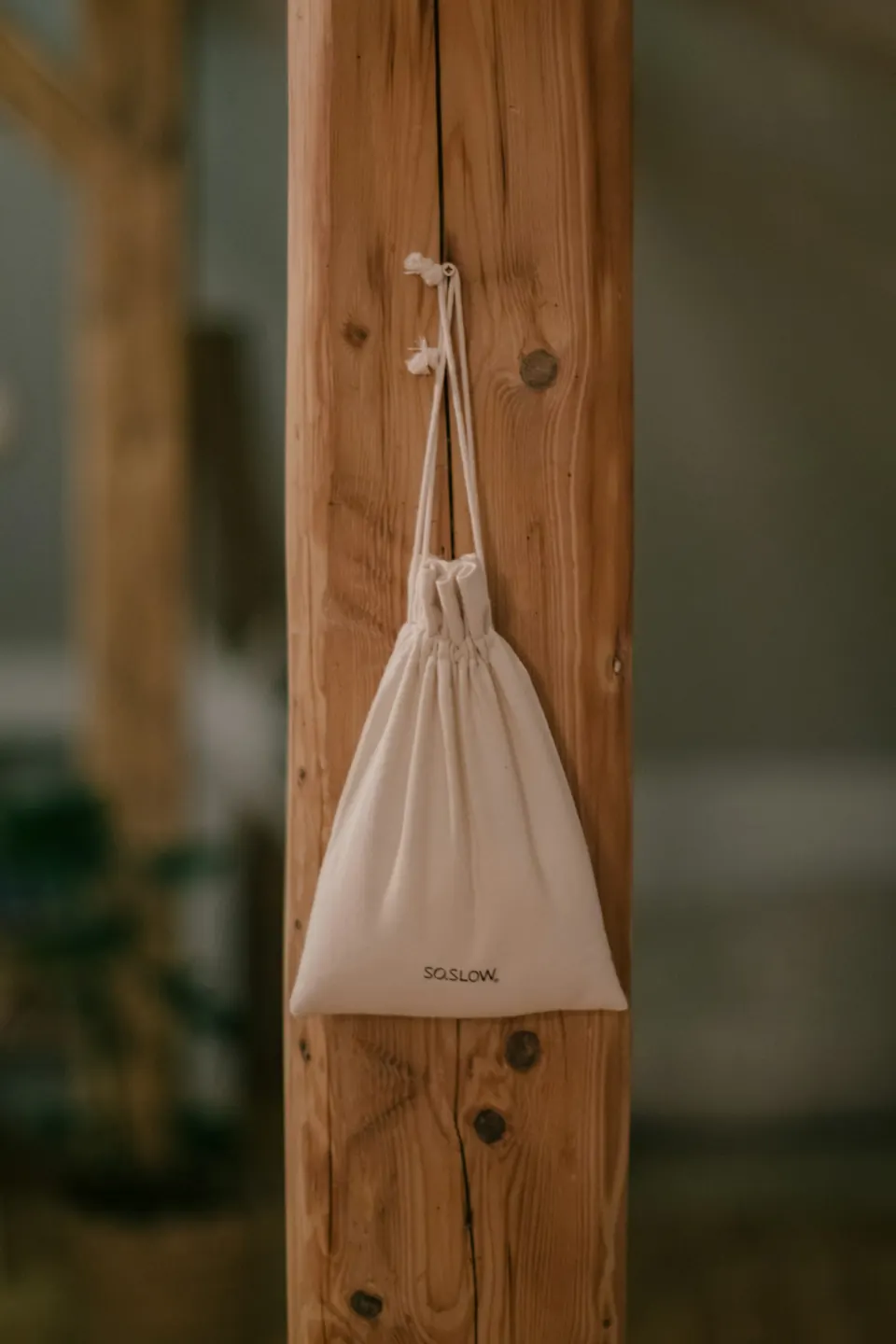 A white bag hanging on a wooden pole