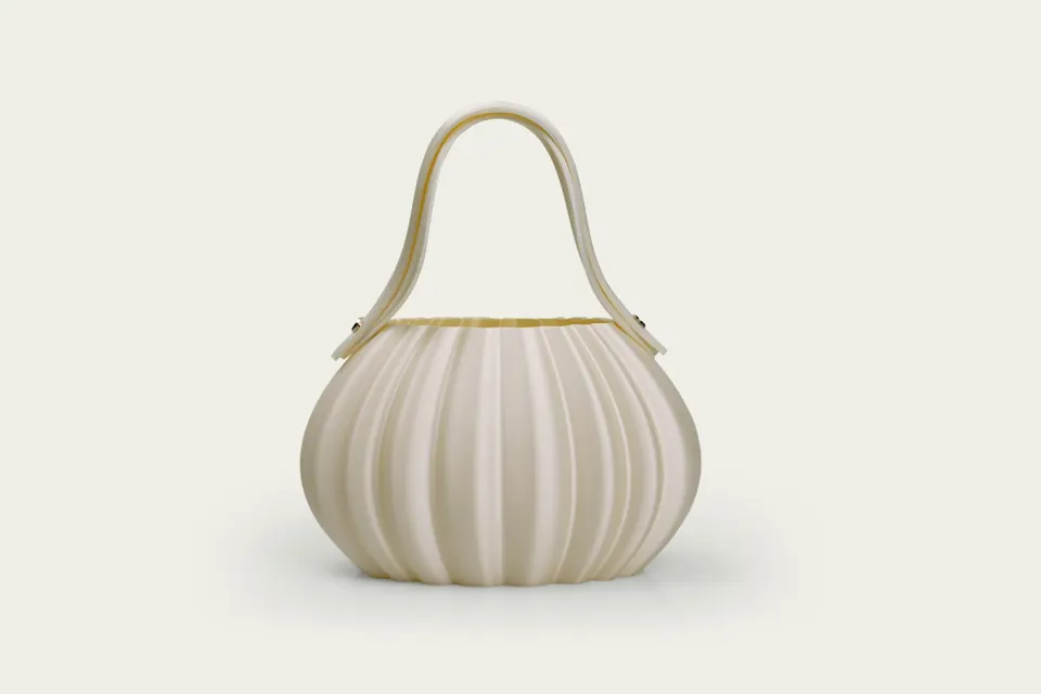 A cream pleated handbag with a curved handle