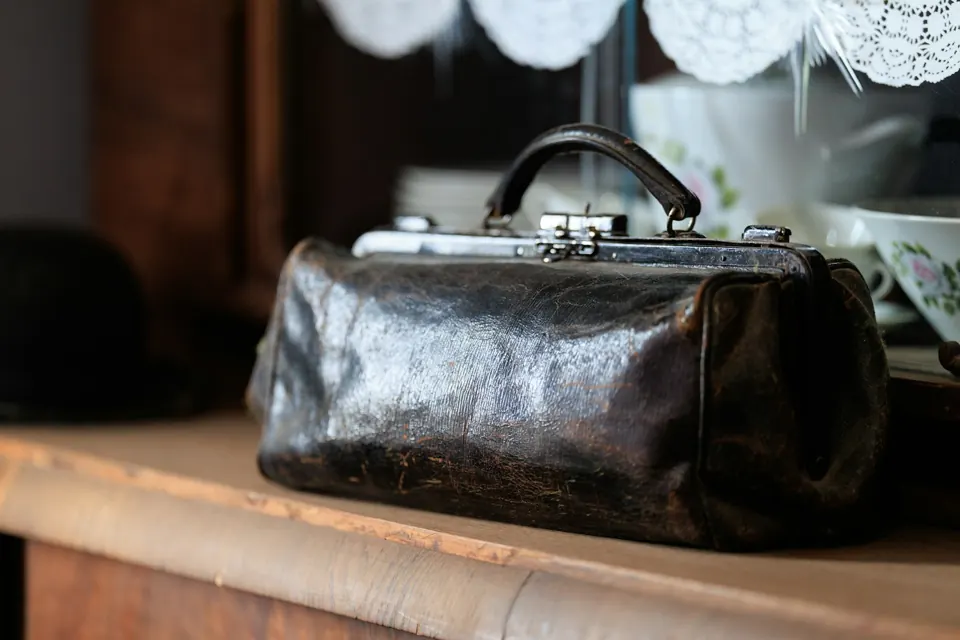 A vintage leather doctor's bag on a shelf