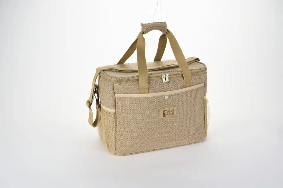 Tan woven cooler bag with handles and a shoulder strap