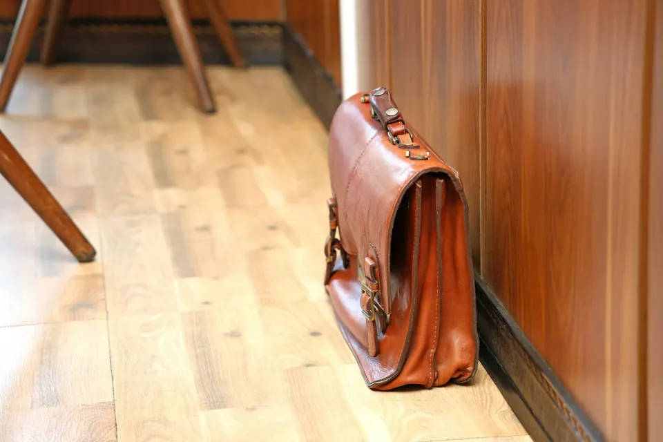 Brown leather briefcase on a wooden floor